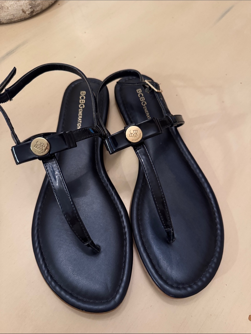 BCBGeneration Navy Blue Patent T-Strap Sandals with Gold Medallion